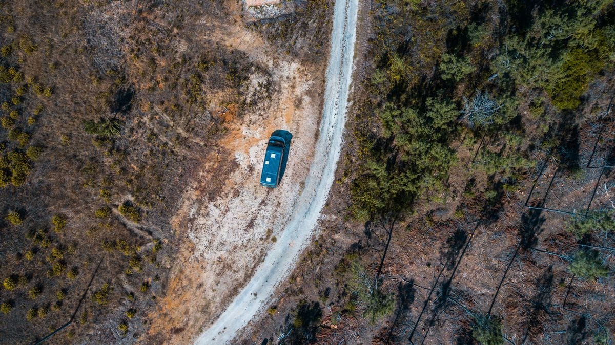 Vista aérea de una furgoneta camper circulando por una carretera rural